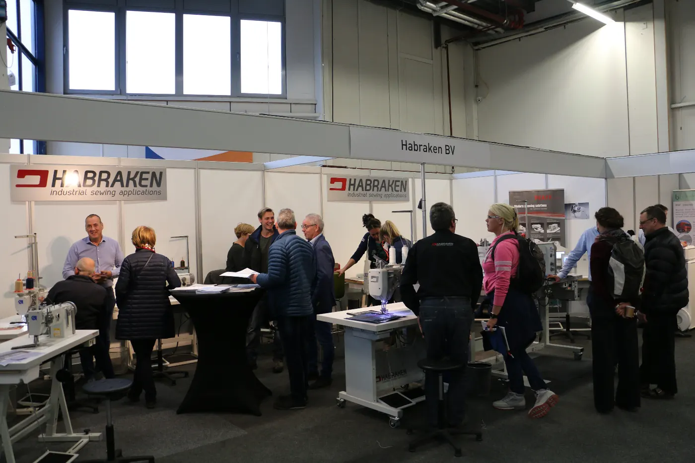 Bezoekers bij de naaimachines op een stand