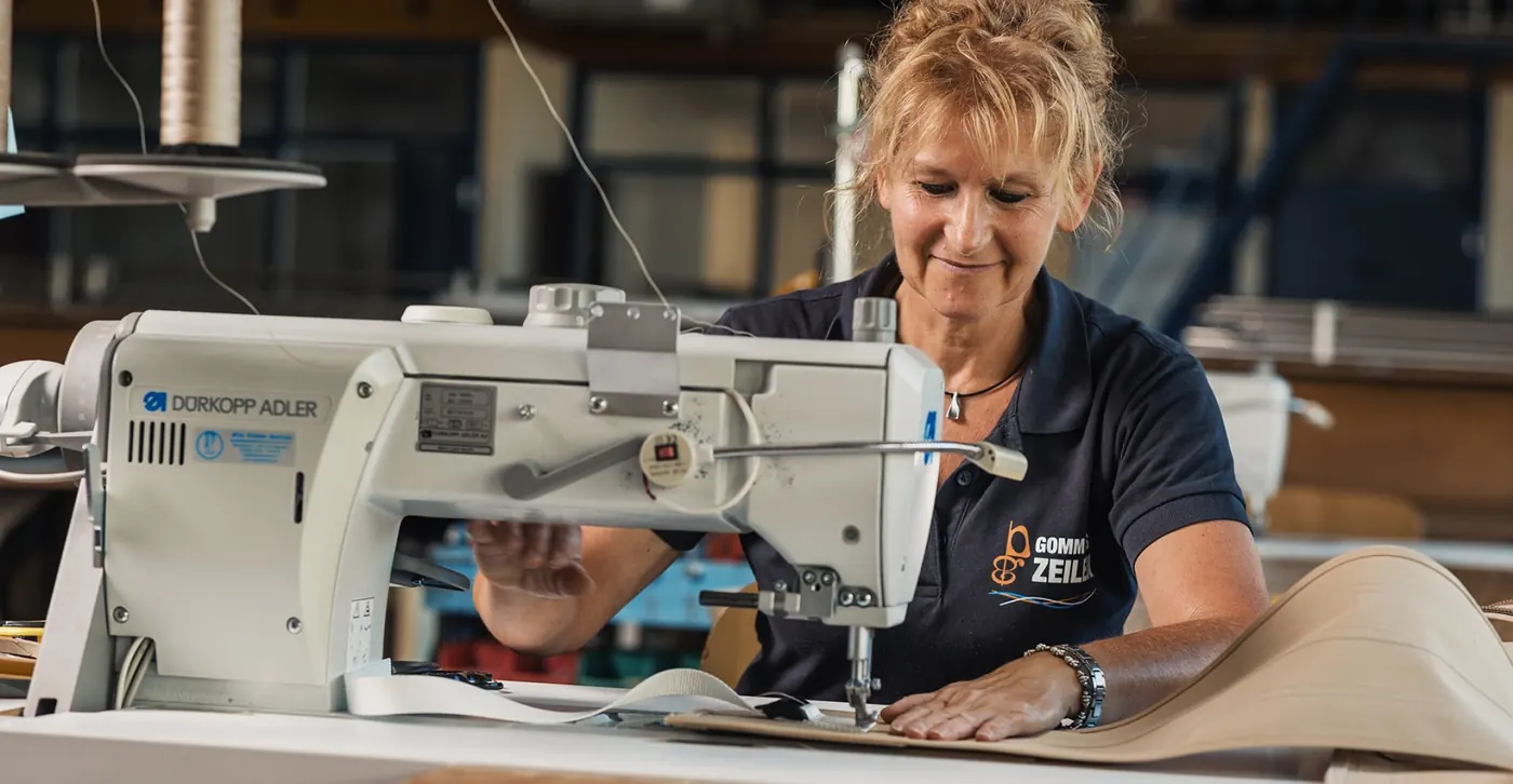 Medewerker van Gommans Zeilen aan de naaimachine