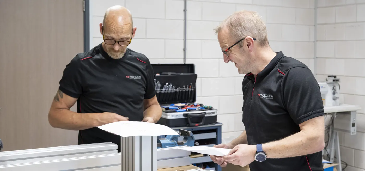 Twee medewerkers van Habraken bij een naaimachine